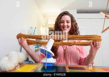 Frau mit Muskeldystrophie, die Arbeit mit ihrem Garn für ihr Geschäft stricken Stockfoto