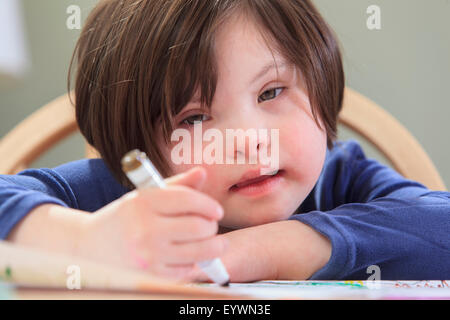 Kind mit Down-Syndrom mit Färbung-Markern Stockfoto