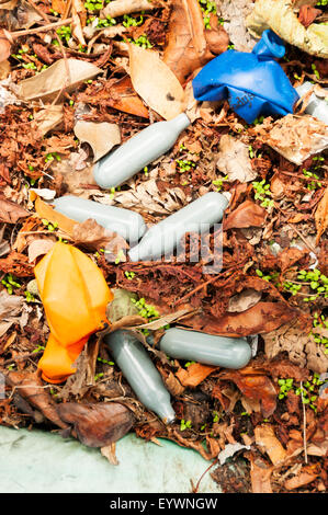 Leere Kanister und Ballons verwendet zum inhalieren die rechtlichen hohe Lachgas neben einer Landstraße aufgegeben. Stockfoto