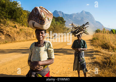 Einheimische Frauen tragen ihre waren auf ihren Köpfen vor Mount Mulanje, Malawi, Afrika Stockfoto