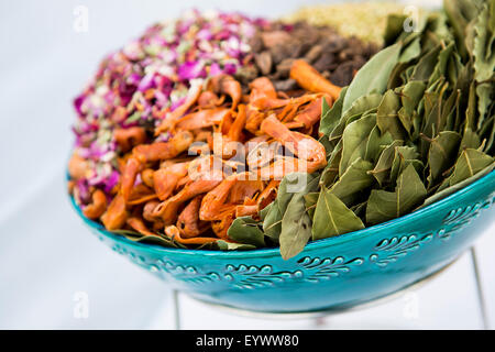 Eine Schüssel mit Gewürzen und Kräutern, die in der indischen Küche einschließlich, Lorbeerblatt, Muskatblüte rose Blumenblätter und schwarzer Kardamom verwendet. Stockfoto