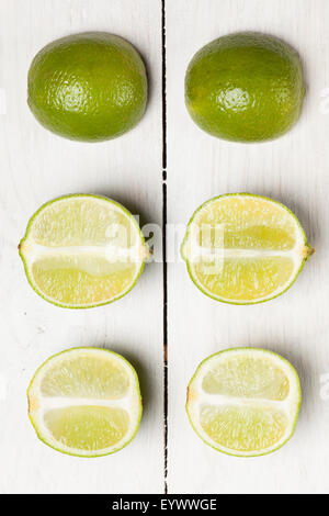 Halbierte Limes auf hölzernen weißen Hintergrund. Stockfoto
