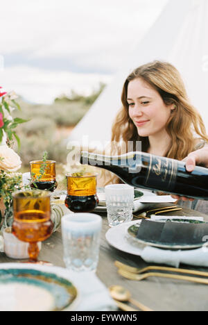 Frauen versammelten sich zum Essen, einem strömenden Rotwein aus der Flasche. Stockfoto