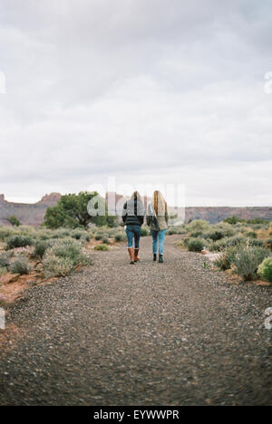 Zwei Frauen gehen auf einem Feldweg in einer Wüste. Stockfoto