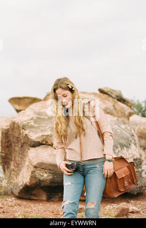 Lächelnde Frau stehend halten eine Leder Tasche. Stockfoto