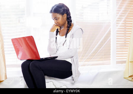 Frustriert ethnischen Mädchen saß im Innenbereich Stockfoto