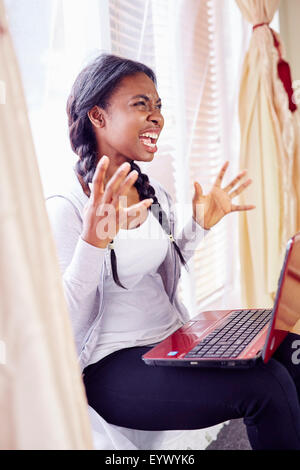 Frustriert ethnischen Mädchen saß im Innenbereich Stockfoto