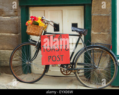 Fahrrad-Schild Werbung Tee, Toast und Post vor einem Café in Robin Hoods Bay in der Nähe von Whitby an der Küste von Yorkshire UK. Stockfoto