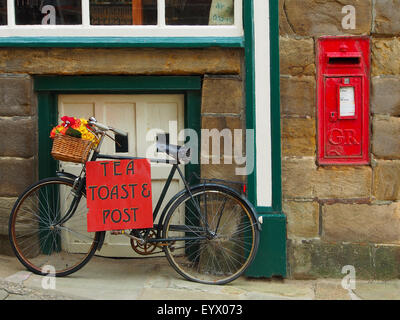 Fahrrad-Schild Werbung Tee, Toast und Post vor einem Café in Robin Hoods Bay in der Nähe von Whitby an der Küste von Yorkshire UK. Stockfoto