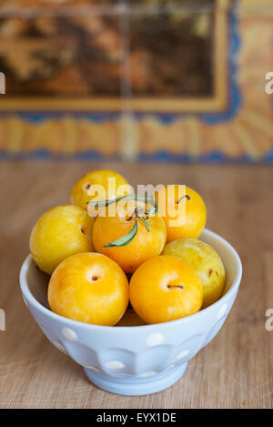 Frische reife gelbe Pflaumen in eine Schüssel geben. Stockfoto