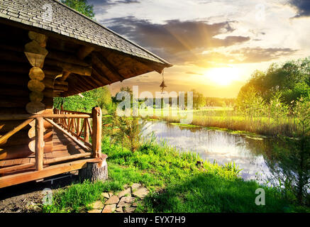 Hölzerne Badehaus in der Nähe von See bei Sonnenuntergang Stockfoto