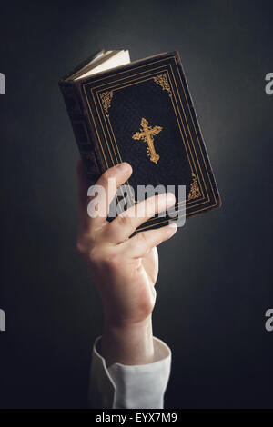 Mann hält eine Bibel in der Luft Stockfoto