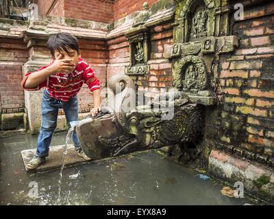 Kathmandu, Nepal. 1. August 2015. Ein kleiner Junge wäscht sein Gesicht mit Wasser aus einem öffentlichen Brunnen in einer Gemeinde in der Nähe von Kathmandu Durbar Square. Viele Häuser in der Gegend nicht Brauchwasser haben und Leute gehen noch zu Brunnen für ihr Wasser. Das Erdbeben im April 2015 beschädigt Infrastruktur, einschließlich der Wasser-System, in diesem Teil der Stadt. © Jack Kurtz/ZUMA Draht/Alamy Live-Nachrichten Stockfoto