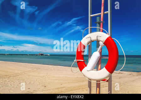 Rettungsring, rote und weiße Rettungsring am Sandstrand der Küste Sommerurlaub Resort Stockfoto