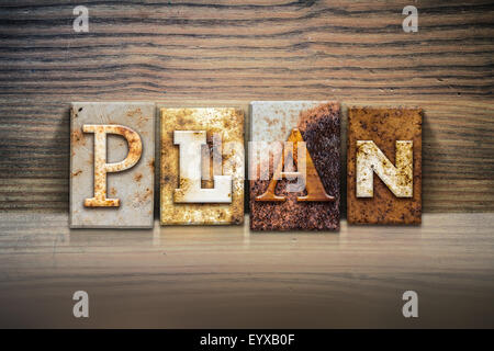 Das Wort "PLAN" in rostigen Metall Buchdruck Typ sitzen auf einem hölzernen Felsvorsprung Hintergrund geschrieben. Stockfoto