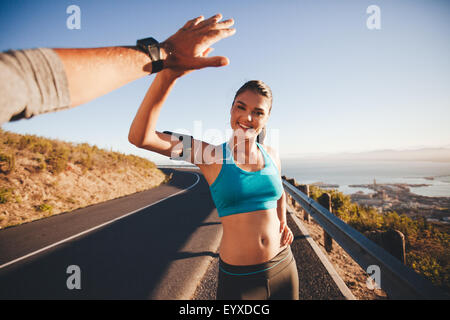 Junge Frau geben hohe fünf zu ihrem Freund nach einem Lauf zu passen. POV Aufnahme von paar hohe Fiving auf Landstraße Morgen. Stockfoto