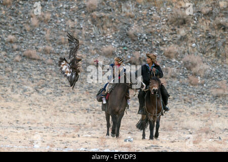 Ein junges Mädchen mit ihrer Assistentin konkurriert im Eagle Festival, Ölgii, westliche Mongolei Stockfoto