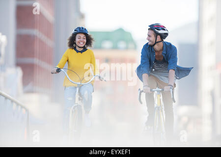 Junges Paar auf Fahrrädern in Stadt Stockfoto