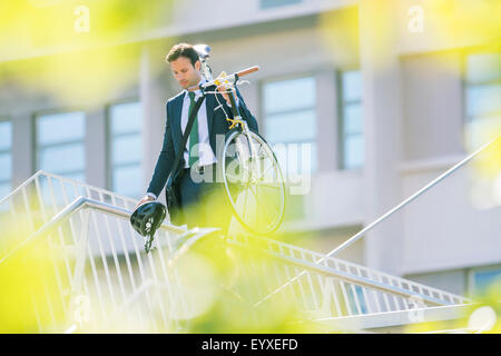 Geschäftsmann im Anzug, mit dem Fahrrad in die Stadt Stockfoto
