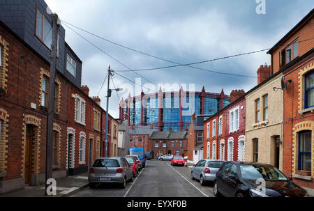 Der Gasometer, jetzt umgewandelt in Wohnungen erhebt sich über kleine terrassierten Housesin Somerset Street, Dublin City, Irland Stockfoto