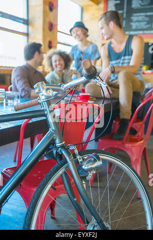 Freunde im Café hinter dem Fahrrad hängen Stockfoto