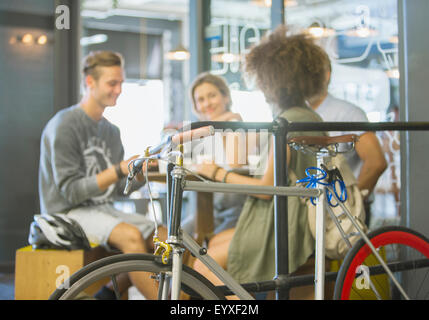 Freunde im Café hinter dem Fahrrad hängen Stockfoto