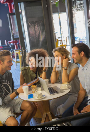 Freunde mit digitalen Tablet und Laptop im Café hängen Stockfoto
