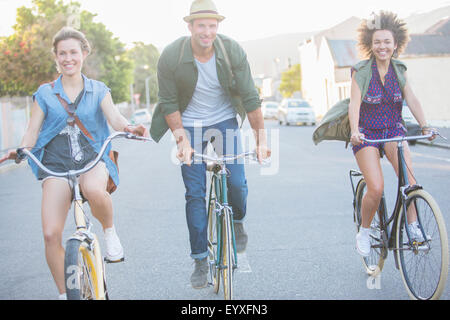 Lächelnden Freunde Fahrrad auf Straße Stockfoto