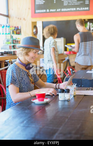 Frau mit Hut, mit digital-Tablette im café Stockfoto