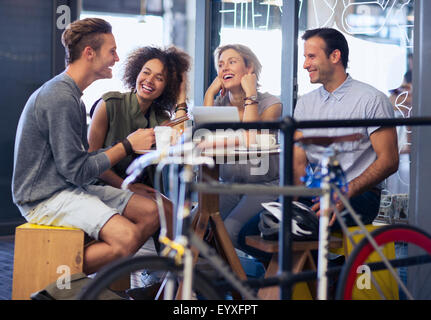 Freunde im Café hinter dem Fahrrad hängen Stockfoto