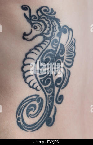 Ein Tattoo tribal Blackstyle Seepferdchen auf eine Frau Rippen. Stockfoto