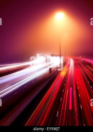 Viel befahrenen Autobahn Ampel Wanderwege in einer nebligen Nacht Highway 401, Toronto, Ontario, Kanada. Stockfoto