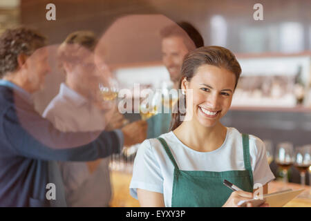 Porträt lächelnde Arbeiter mit Zwischenablage im Weingut Degustationsraum Stockfoto