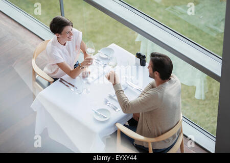 Paar, toasten Weingläser an Restauranttisch am Fenster Stockfoto
