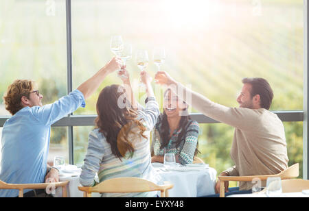 Freunde, toasten Weingläser overhead an Weingut Esstisch Stockfoto