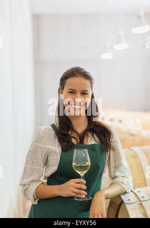 Porträt zuversichtlich Winzer mit Weißwein im Keller Stockfoto
