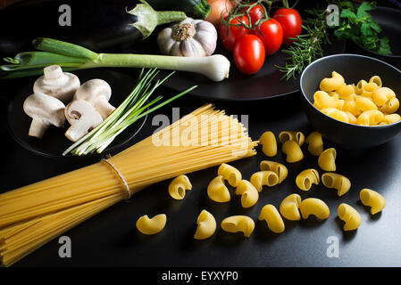 Pasta-Kollektion mit frischen Zutaten auf einem schwarzen Hintergrund. Stockfoto