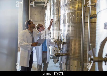 Winzer in Laborkitteln Überprüfung Bottiche im Weingut Keller Stockfoto