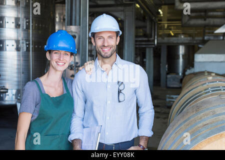 Porträt zuversichtlich Weingut Mitarbeiter in harte Hüte im Keller Stockfoto