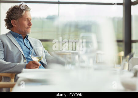 Nachdenklicher Mann trinken Weißwein im Weingut Speisesaal Stockfoto