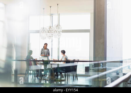 Geschäftsfrau, die Kollegen im sonnigen Konferenzraum zu präsentieren Stockfoto
