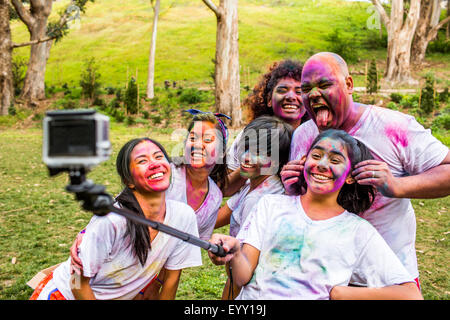 Freunde in Pigmentpulver mit Selfie-Stick abgedeckt Stockfoto