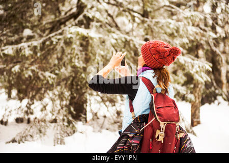 Kaukasische Frau fotografieren Natur auf verschneiten Weg Stockfoto