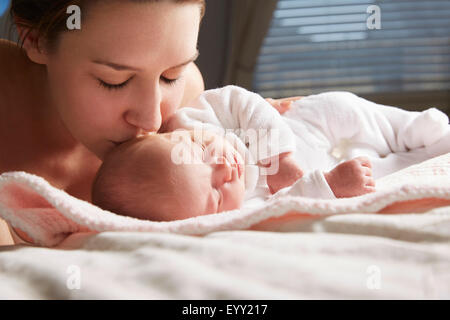 Mutter, küssen neugeborenes Baby auf Decke Stockfoto