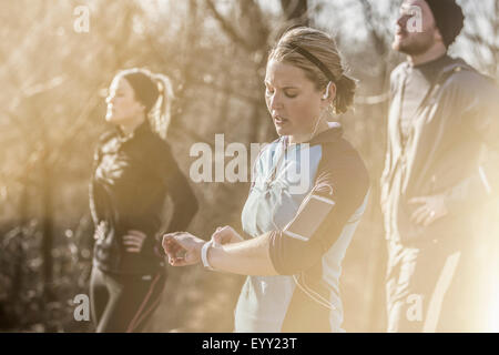 Kaukasische Läufer Überprüfung Fitness Uhr im Wald Stockfoto