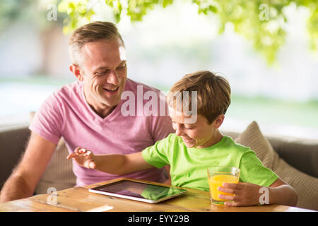 Kaukasische Vater und Sohn mit digitalen Tablet im freien Stockfoto