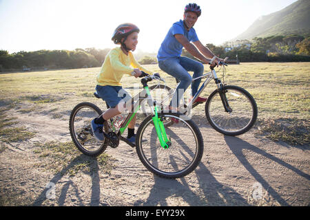 Kaukasische Vater und Sohn auf Fahrrädern auf Feldweg Stockfoto