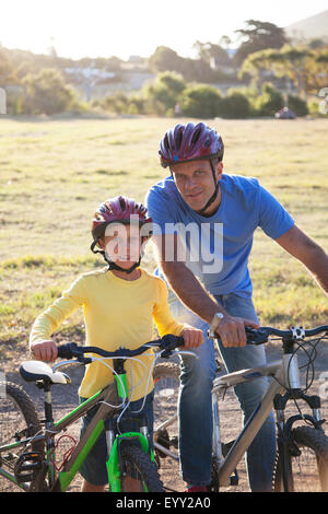 Kaukasische Vater und Sohn auf Fahrrädern auf Feldweg Stockfoto