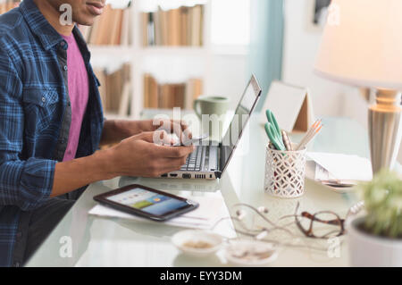 Schwarze Geschäftsmann Multitasking am Schreibtisch Stockfoto