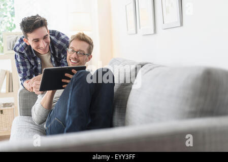 Kaukasische schwules Paar mit digital-Tablette auf sofa Stockfoto